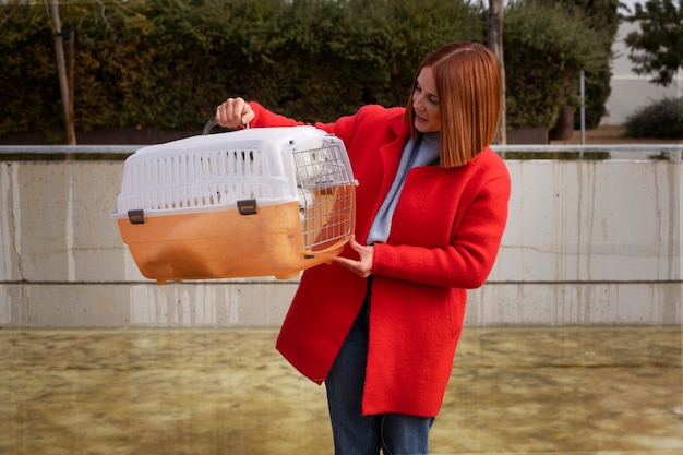 Mujer de tiro medio con transportador de mascotas.