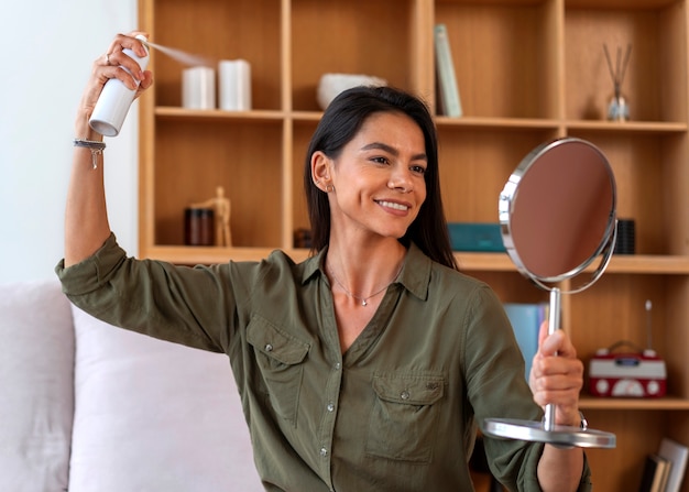 Foto mujer de tiro medio usando champú seco en casa