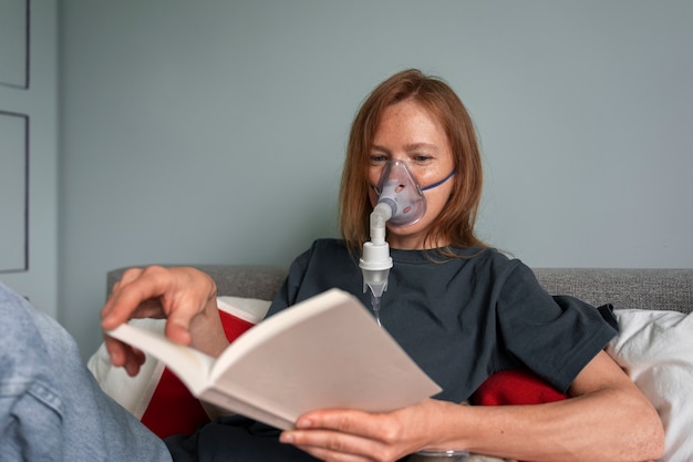 Foto mujer de tiro medio usando nebulizador en casa