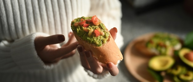 Mujer de tiro recortada con sándwiches de aguacate.