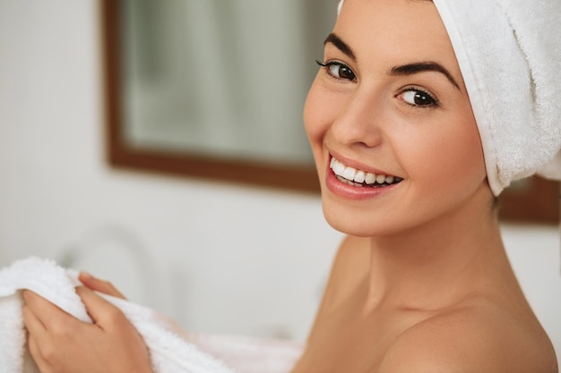 Mujer con toalla de baño sonriendo