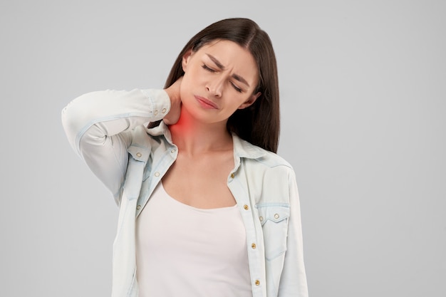 Mujer tocando el cuello por dolor