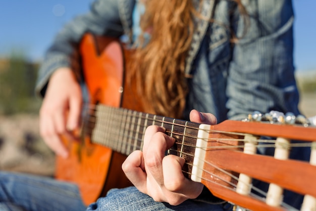 Mujer tocando la guitarra y la costa