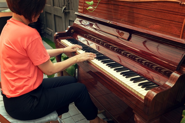 mujer tocando el piano vista posterior