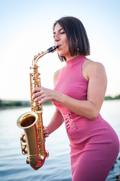 Mujer tocando el saxofón al atardecer