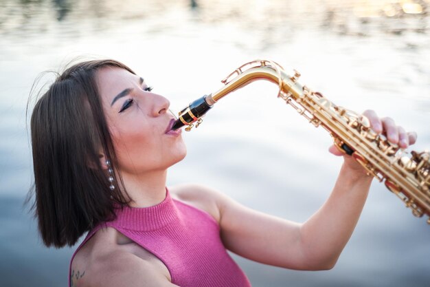 Mujer tocando el saxofón al atardecer
