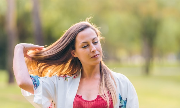 Foto mujer tocando su cabello en un parque