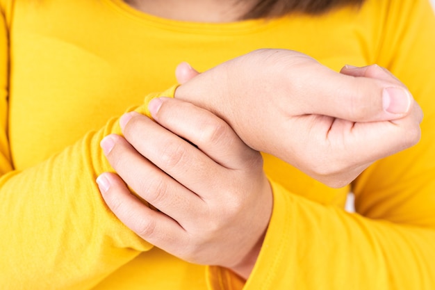 Mujer tocando su dolor de muñeca.