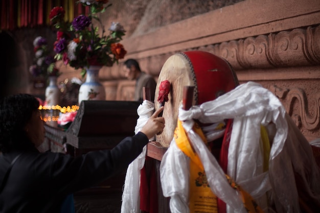 Foto mujer tocando el tambor en el templo