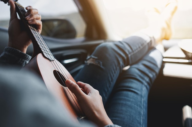 Una mujer tocando el ukelele mientras viaja en el auto