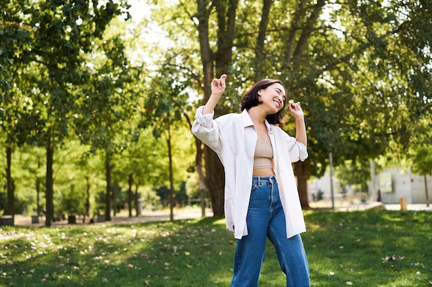 Mujer de toda la longitud de pie contra los árboles