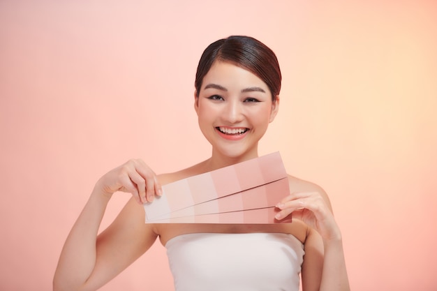 Mujer toma escala de color de piel sobre fondo beige