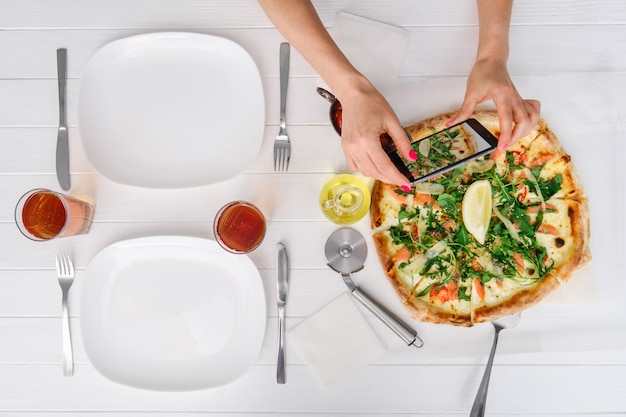 Mujer toma una foto de pizza