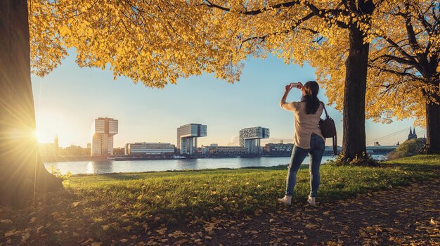 Mujer toma una foto del Skyline de Colonia en otoño