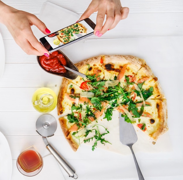 Mujer toma fotos de pizza