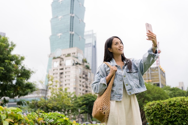 Mujer se toma una selfie con su teléfono móvil en la ciudad de Taipei