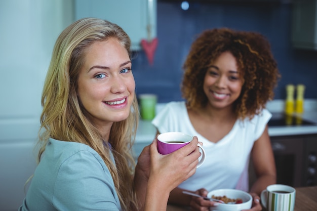 Mujer tomando café con amiga en la mesa