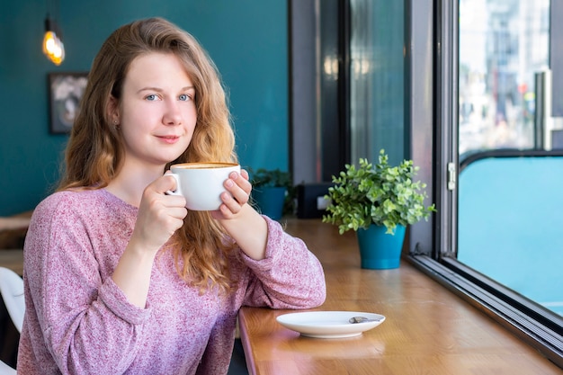 Mujer tomando café en la cafetería cafetería