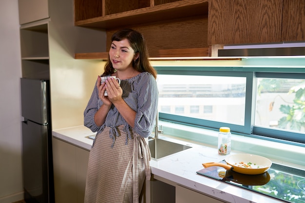 Mujer tomando café en la cocina