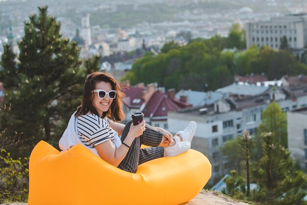 Mujer tomando café con hermosa vista de la puesta de sol sobre la ciudad de lviv en ucrania