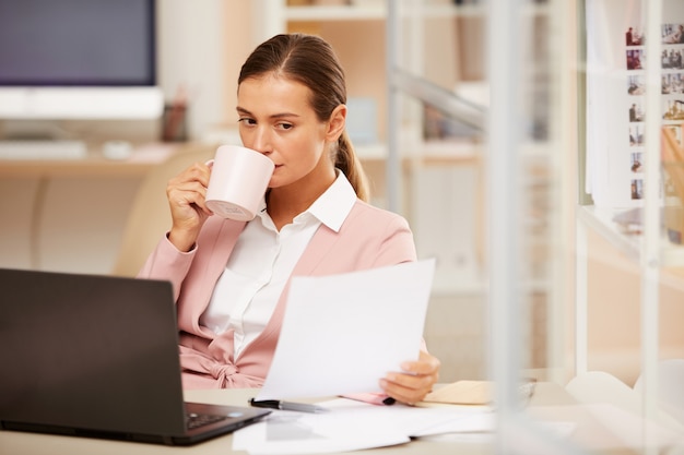 Mujer tomando café durante la jornada laboral
