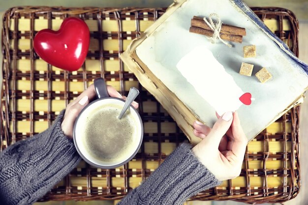 Mujer tomando café y mirando la tarjeta de San Valentín