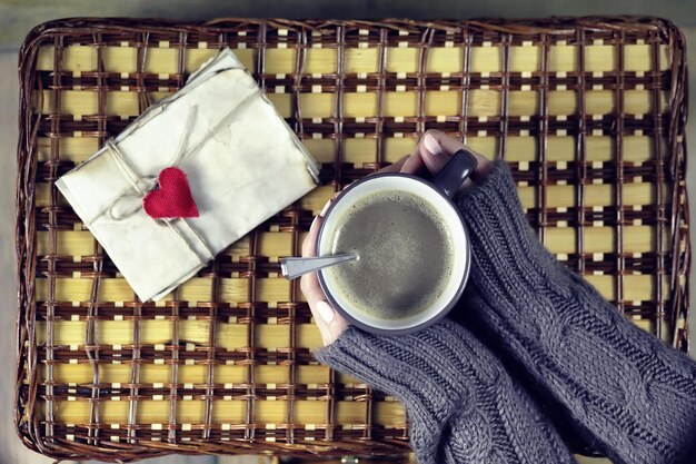 Mujer tomando café y mirando la tarjeta de San Valentín