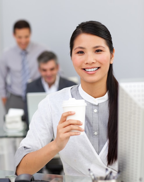 Mujer tomando café en la oficina