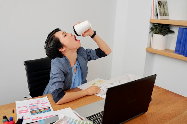 Mujer tomando café en la oficina