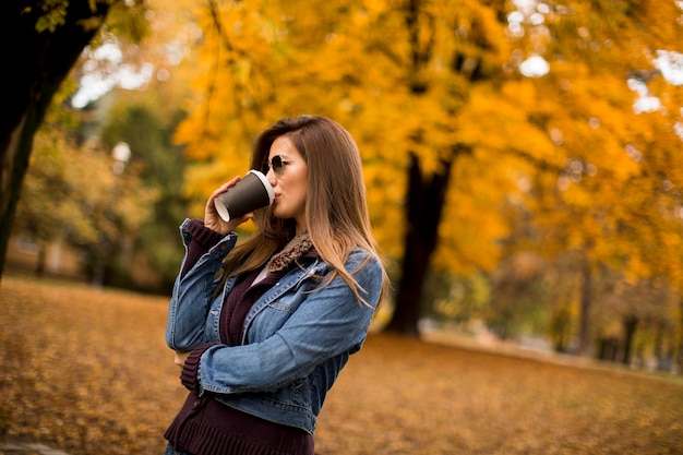 Mujer tomando café en el parque otoño