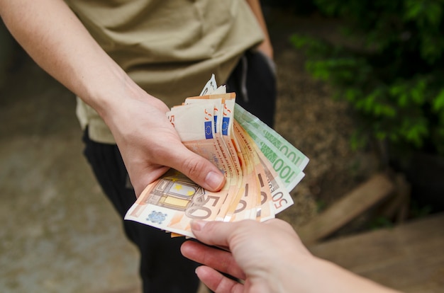 Mujer tomando dinero de la mano del hombre