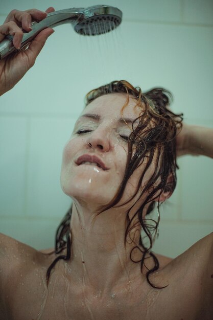 Foto mujer tomando una ducha en el baño