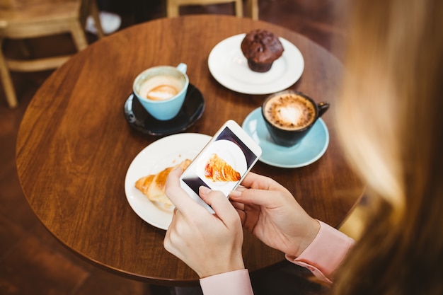 Mujer tomando foto de comida