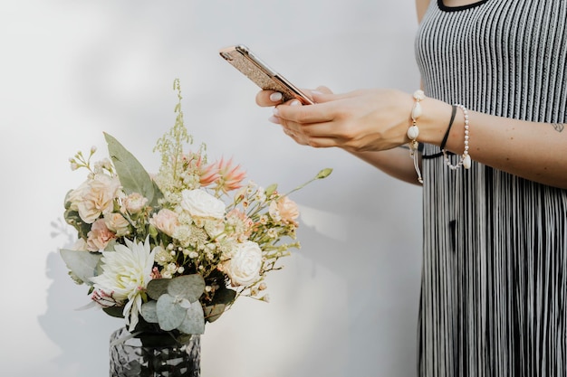 Mujer tomando una foto de flores con un teléfono