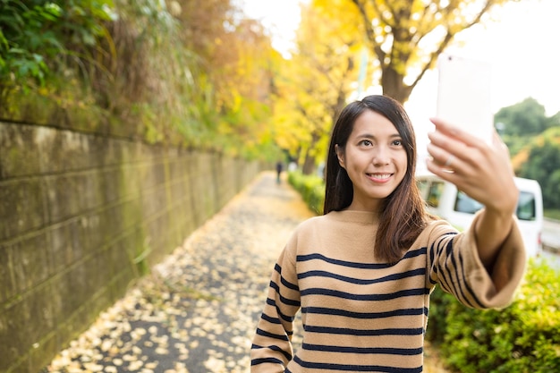 Mujer tomando foto por teléfono móvil