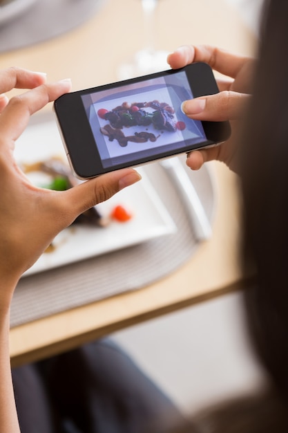 Mujer tomando fotografía de comida