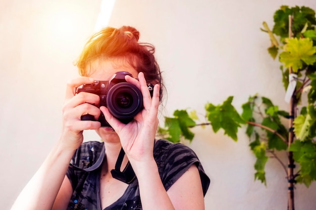 Mujer tomando fotos al aire libre con luz solar