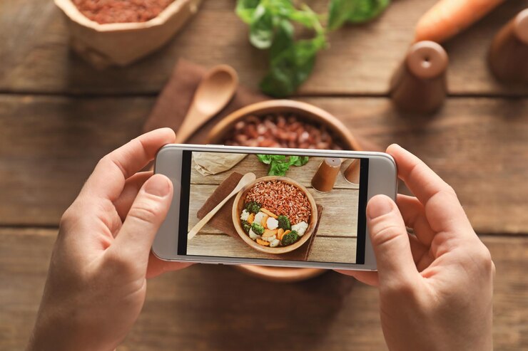 Foto mujer tomando fotos de comida con teléfono móvil en la cocina
