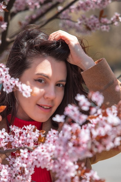 Mujer tomando fotos en el floreciente árbol de sakura