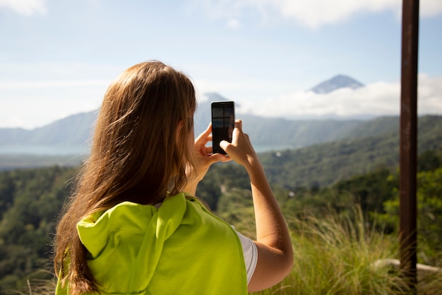 mujer tomando fotos de montañas con smartphone