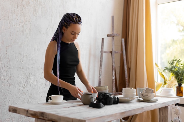 Foto mujer tomando fotos de utensilios de cocina de cerámica en casa