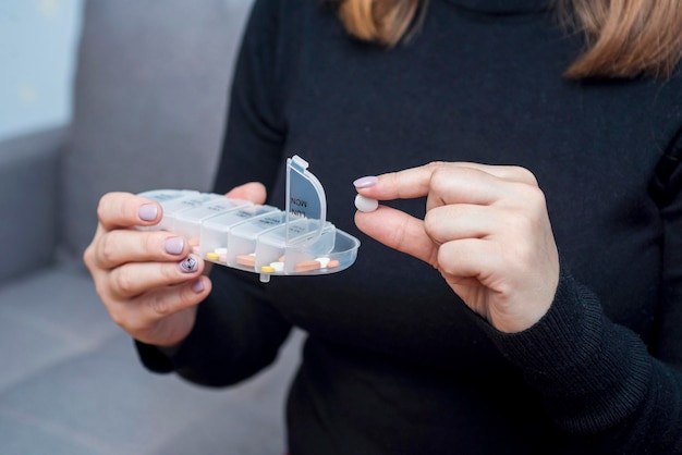 Mujer tomando medicamentos de la caja de pastillas concepto de atención y tratamiento de la salud