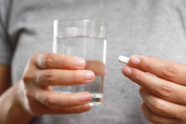 Mujer tomando medicamentos para tratar los síntomas de la enfermedad.