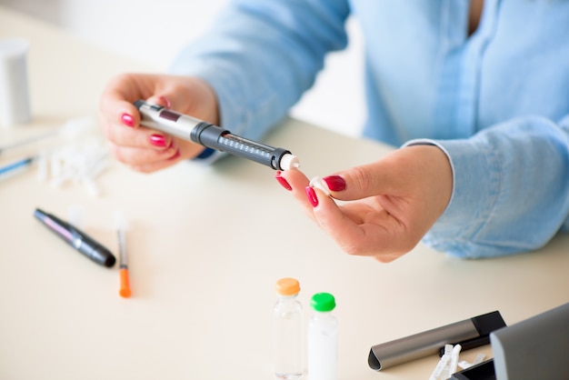 Mujer tomando muestra de sangre con lanceta. Diabetes.