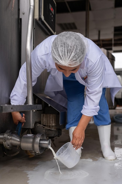 Mujer tomando muestras de leche de un tanque