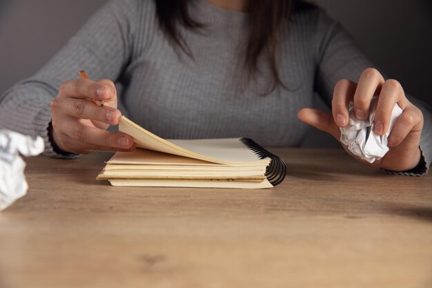 Mujer tomando notas en un cuaderno con papel arrugado