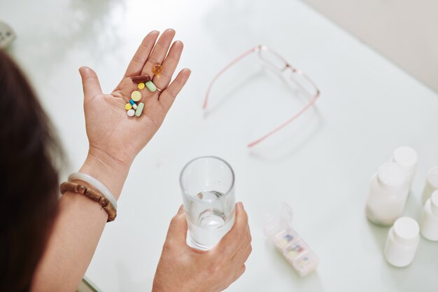 Mujer tomando pastillas y suplementos