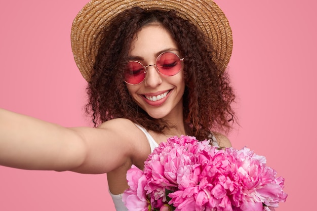 Mujer tomando selfie con flores