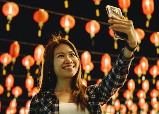 Mujer tomando selfie en linterna festval