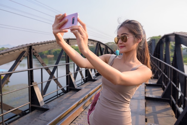 Mujer tomando selfie en la muerte del puente ferroviario sobre el río Kwai